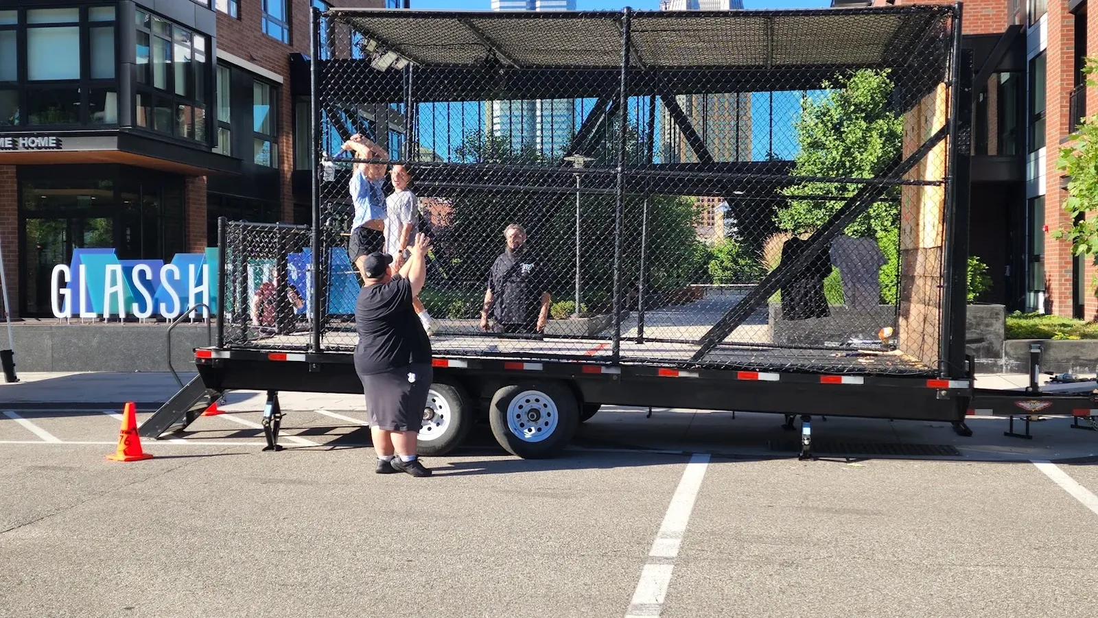 Guests throwing axes in the AXE 376 trailer on a sunny city street